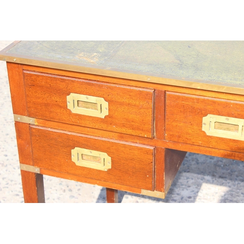 85 - An early 20th century style mahogany and leather topped campaign desk formed as a central long drawe... 