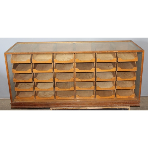 81 - An early 20th century light oak haberdashery shop counter or display cabinet with 30 drawers with br... 