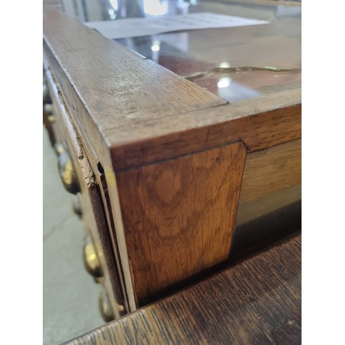 81 - An early 20th century light oak haberdashery shop counter or display cabinet with 30 drawers with br... 