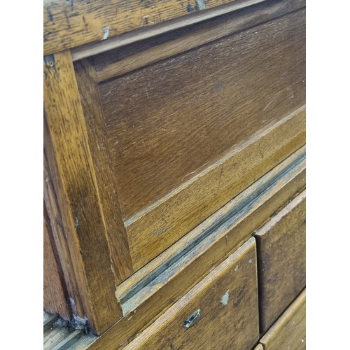 82 - An early 20th century light oak haberdashery shop counter or display cabinet with 15 drawers with br... 