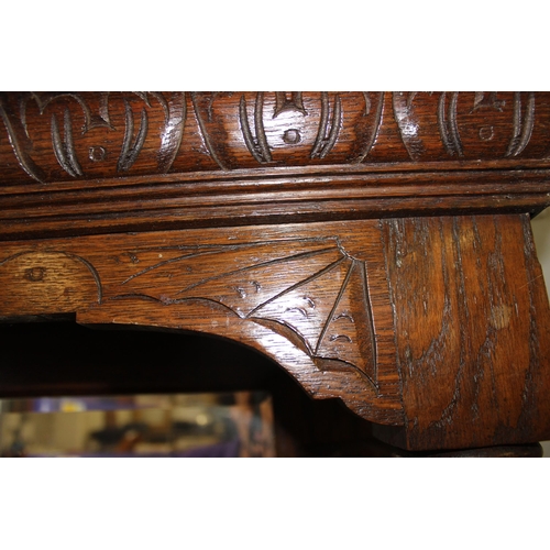 50 - An antique 17th century style carved oak sideboard or chiffonier with mirror back and lion mask hand... 