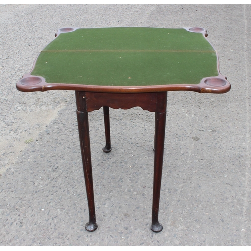 8 - An antique mahogany card table with baize interior and pad feet, approx 79cm square when open