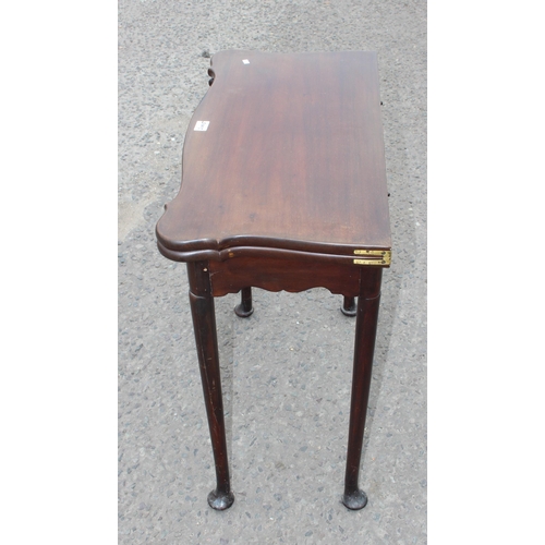 8 - An antique mahogany card table with baize interior and pad feet, approx 79cm square when open