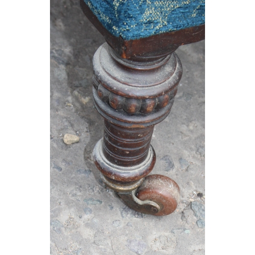 17 - A Victorian low seated armchair with blue patterned upholstery and turned legs