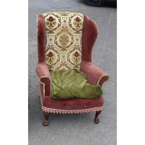 18 - A pair of antique wingback armchairs with later upholstery, short wooden legs ending in carved lion ... 