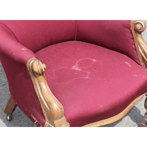 29 - A Victorian armchair with maroon upholstery and carved details