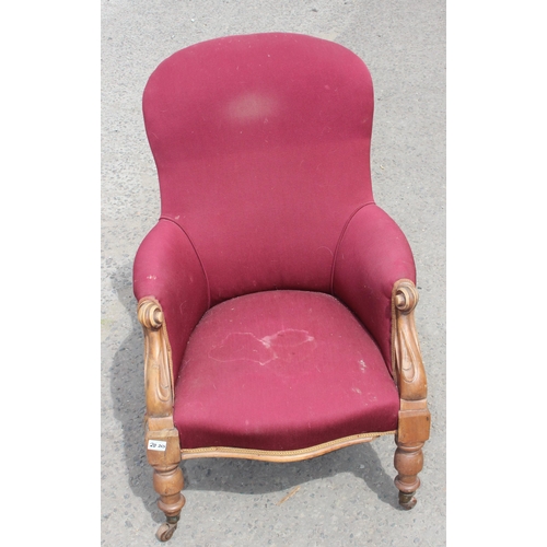 29 - A Victorian armchair with maroon upholstery and carved details