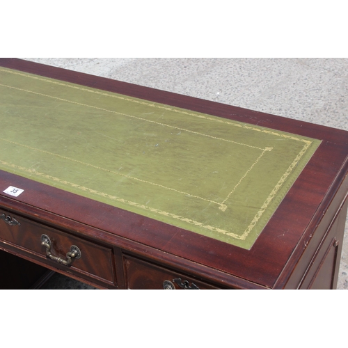 35 - An antique style mahogany pedestal desk with green leather top, approx 122cm wide x 61cm deep x 77cm... 