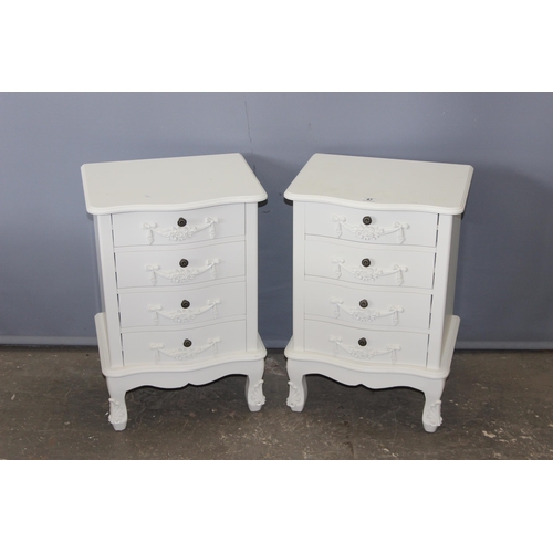 47 - A pair of vintage style white painted 4 drawer bedside cabinets with decorative floral swags and met... 