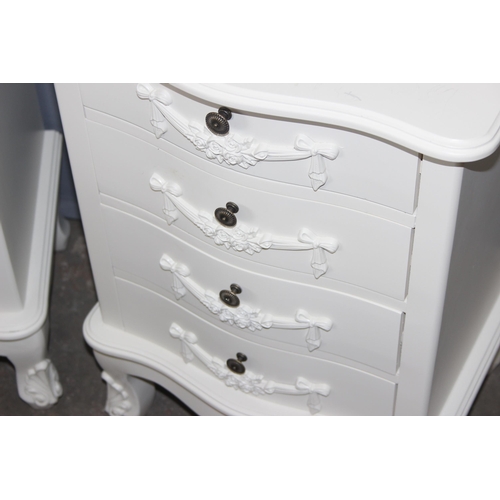 47 - A pair of vintage style white painted 4 drawer bedside cabinets with decorative floral swags and met... 