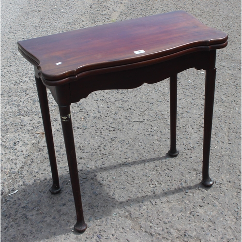 8 - An antique mahogany card table with baize interior and pad feet, approx 79cm square when open