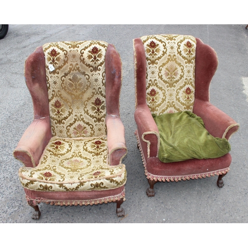 55 - A pair of antique wingback armchairs with later upholstery, short wooden legs ending in carved lion ... 