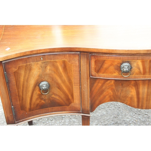 34 - An antique style flame mahogany serpentine sideboard with a central drawer flanked by 2 cupboards, a... 