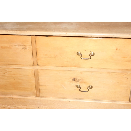 15 - An antique pine 4 drawer low chest of drawers with brass handles, replacement top, approx 124cm wide... 