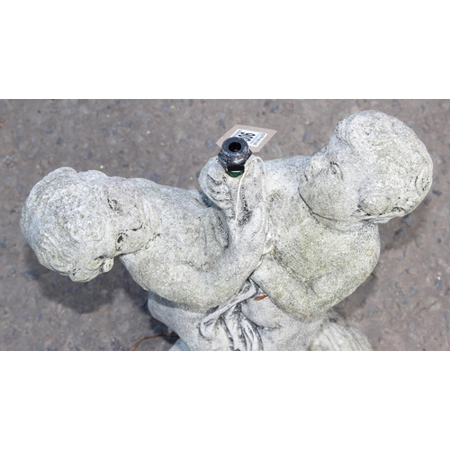 306 - A small concrete garden fountain formed as 2 cherubs, approx 52cm tall