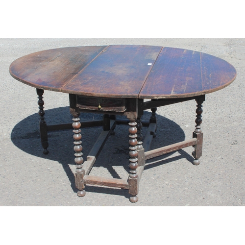 48 - An antique oak dropleaf table with turned supports and single drawer, likely 18th century, approx 15... 