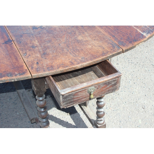 48 - An antique oak dropleaf table with turned supports and single drawer, likely 18th century, approx 15... 