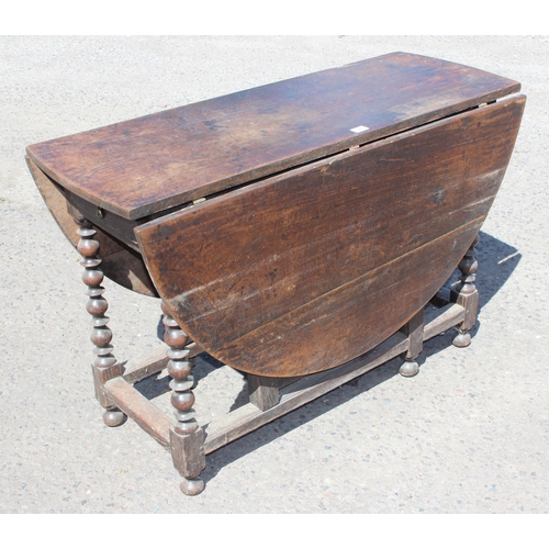 48 - An antique oak dropleaf table with turned supports and single drawer, likely 18th century, approx 15... 