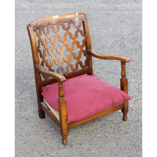 91 - An Art Deco period low armchair with unusual fretwork back