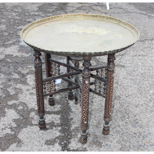 105 - A vintage Benares brass topped Bedouin tea table with folding wooden base, approx 60cm wide x 54cm t... 