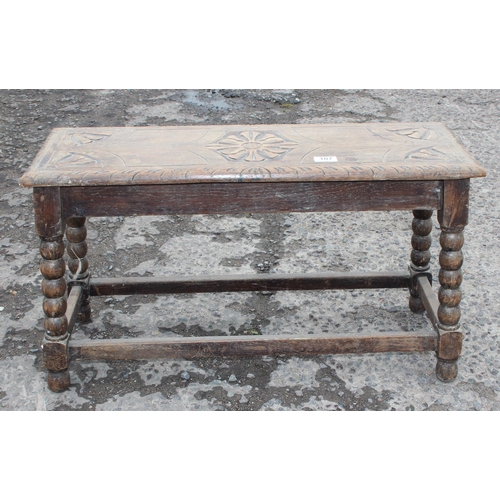 107 - An early 20th century oak bench with bobbin turned supports and carved top, approx 78cm wide x 27cm ... 