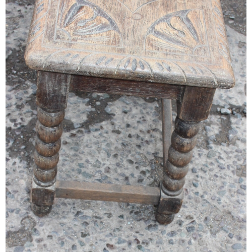 107 - An early 20th century oak bench with bobbin turned supports and carved top, approx 78cm wide x 27cm ... 