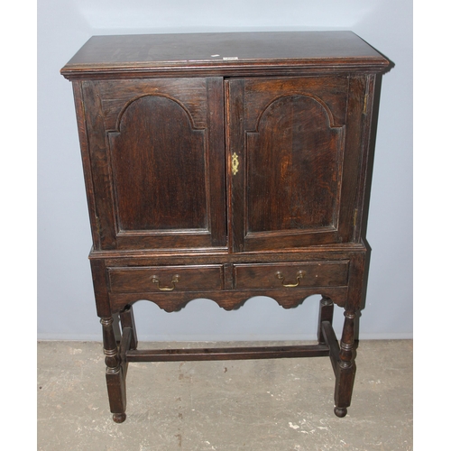 109 - An antique dark oak 2 door cabinet over 2 drawers, on turned wooden legs, likely late 19th century i... 