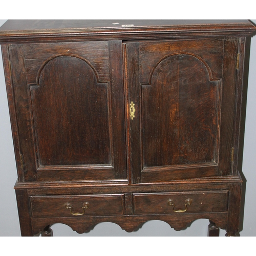 109 - An antique dark oak 2 door cabinet over 2 drawers, on turned wooden legs, likely late 19th century i... 