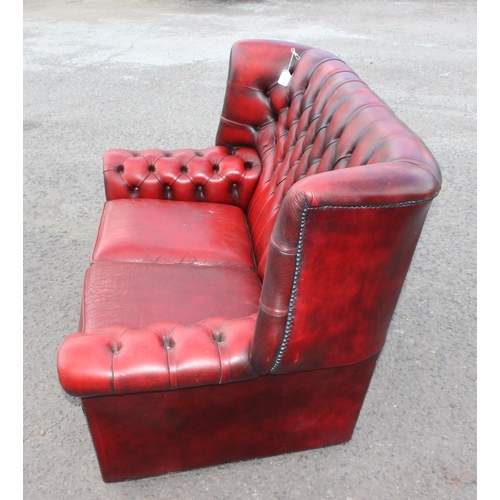 151 - An Ox-Blood red Chesterfield wing back 2 seater sofa, approx 143cm wide x 95cm deep x 96cm tall