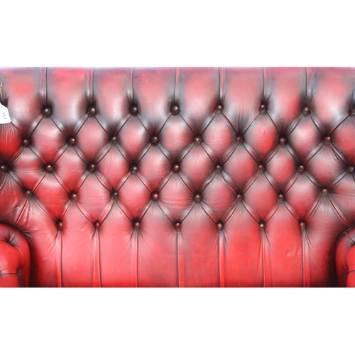 151 - An Ox-Blood red Chesterfield wing back 2 seater sofa, approx 143cm wide x 95cm deep x 96cm tall