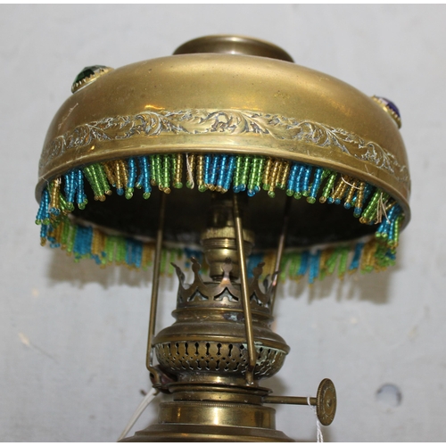 269 - A vintage brass lamp with brass shade with beadwork edging, approx 30cm tall