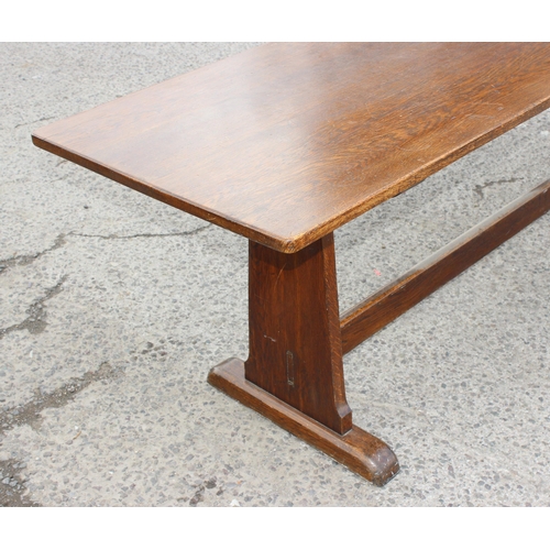 164 - An antique oak refectory table standing on sledge feet united by a stretcher, previously from a mili... 