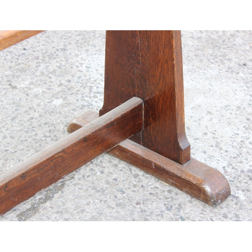 164 - An antique oak refectory table standing on sledge feet united by a stretcher, previously from a mili... 