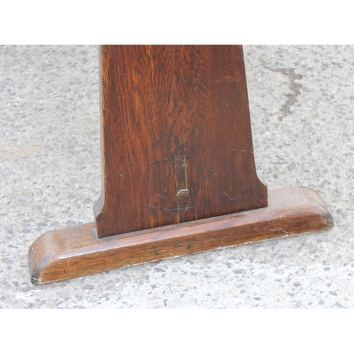 164 - An antique oak refectory table standing on sledge feet united by a stretcher, previously from a mili... 