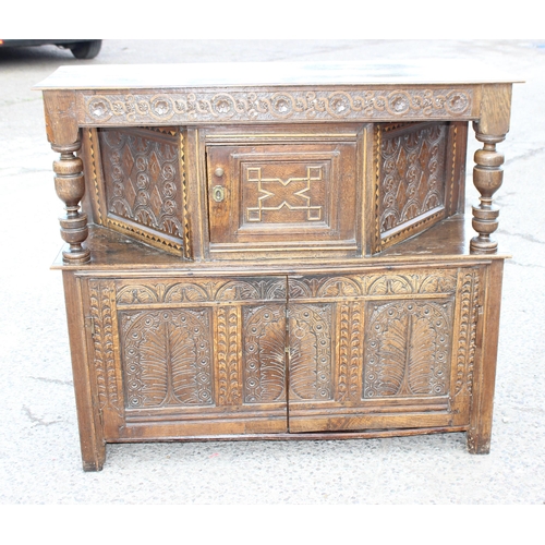 165 - An antique English oak court cupboard formed from a 17th century coffer, profusely carved and with g... 