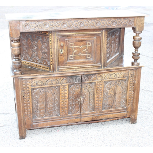 165 - An antique English oak court cupboard formed from a 17th century coffer, profusely carved and with g... 