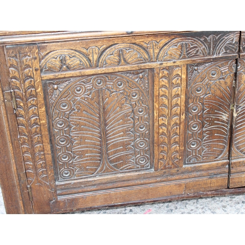 165 - An antique English oak court cupboard formed from a 17th century coffer, profusely carved and with g... 