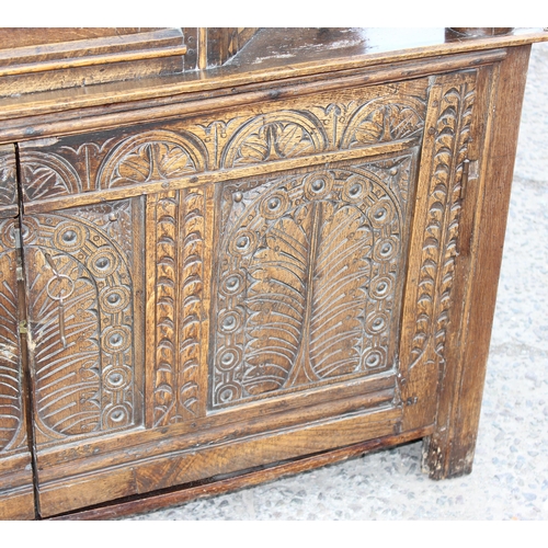 165 - An antique English oak court cupboard formed from a 17th century coffer, profusely carved and with g... 