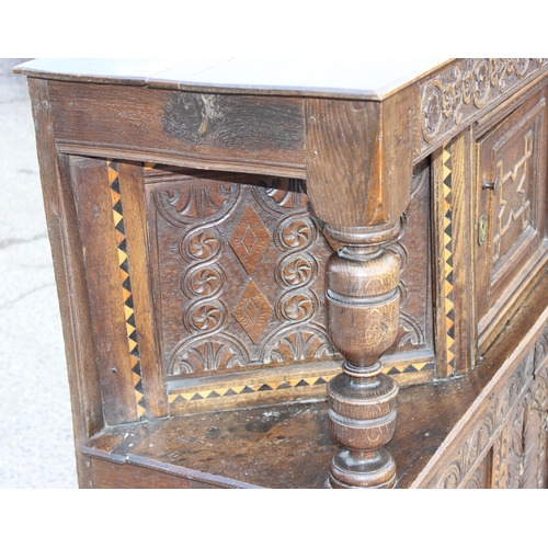 165 - An antique English oak court cupboard formed from a 17th century coffer, profusely carved and with g... 