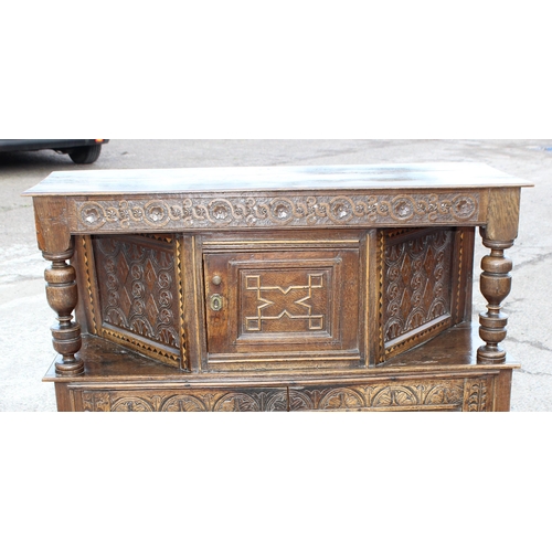 165 - An antique English oak court cupboard formed from a 17th century coffer, profusely carved and with g... 