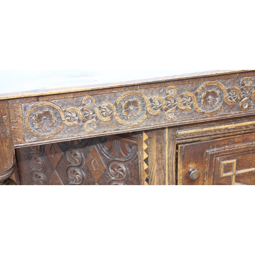 165 - An antique English oak court cupboard formed from a 17th century coffer, profusely carved and with g... 