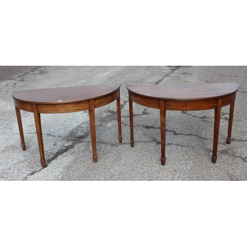 169 - A pair of antique mahogany demi-lune hall tables with spade legs, each approx 120cm wide x 57cm deep... 