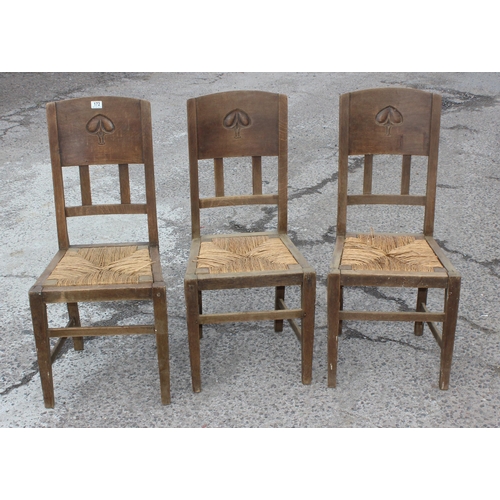 172 - A set of 3 Arts & Crafts period oak chairs with rush seat, the back rest carved with an Art Nouveau ... 