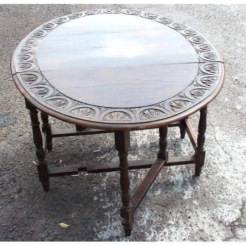 14 - An antique oak drop leaf table with carved details. approx 150cm wide x 107cm deep x 73cm tall