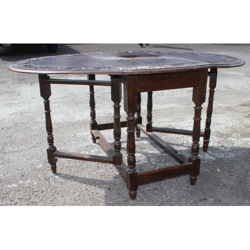 14 - An antique oak drop leaf table with carved details. approx 150cm wide x 107cm deep x 73cm tall