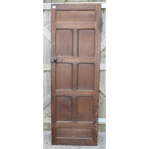 182 - An antique oak panel door with wrought iron hinges, approx 67cm x 196cm