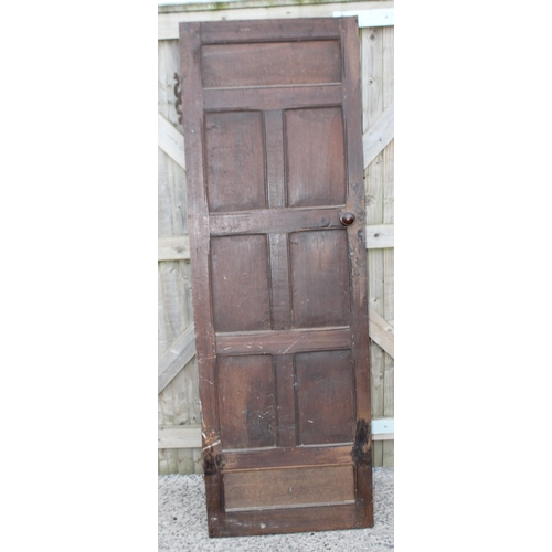 182 - An antique oak panel door with wrought iron hinges, approx 67cm x 196cm