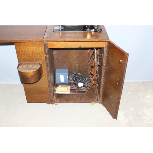 35 - A vintage Singer sewing machine table or cabinet with machine, approx 53cm wide x 43cm deep x 83cm t... 