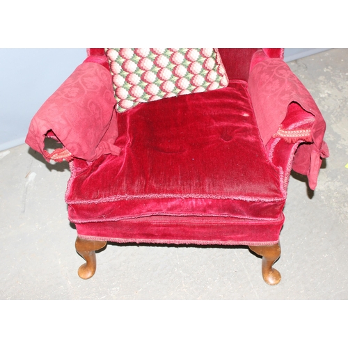 17 - A vintage red velvet covered wingback armchair, approx 98cm tall