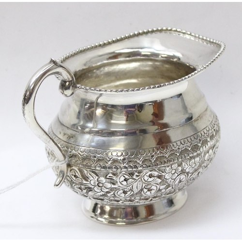 1035 - A large embossed silver cream or milk jug, likely Anglo-Indian, marked St Silver to the base and XRF... 